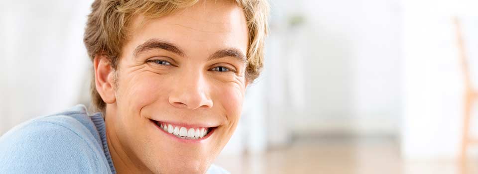 man smiles in dental office
